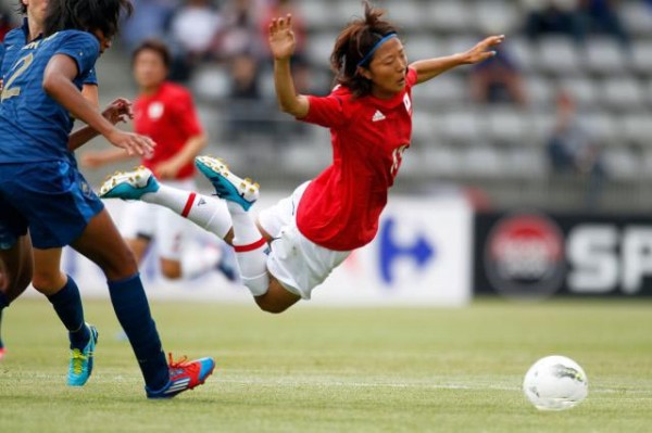 Japanese women footballers Ogimi Yuki looked tackled by French player