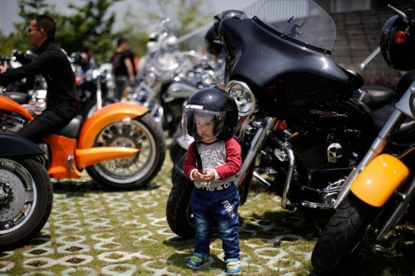 Local boy is photographed near the Harley Davidson motorcycle at the annual rally