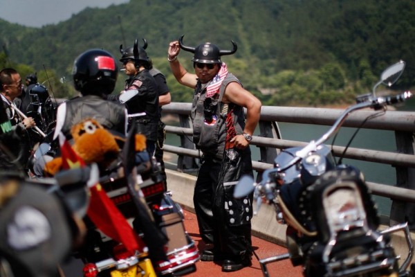 Biker dancing at the annual Harley Davidson rally at Lake Qiandaohu in Zhejiang Province, China