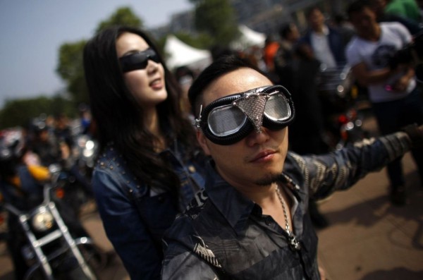 Young man and woman riding a motorcycle Harley Davidson during the annual rally in Qiandaohu Lake in Zhejiang Province, China