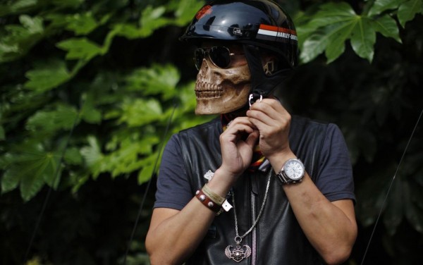 A man in a mask skeleton is preparing to participate in the annual Harley Davidson rally 
