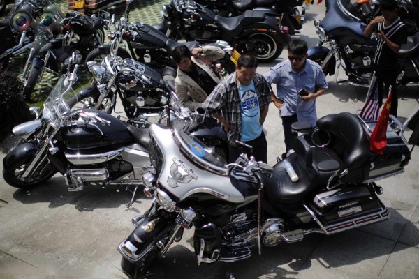 Local residents inspect a Harley Davidson motorcycle during the annual rally